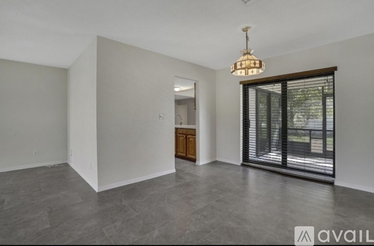A room with a wooden cabinet and a chandelier hanging from the ceiling.