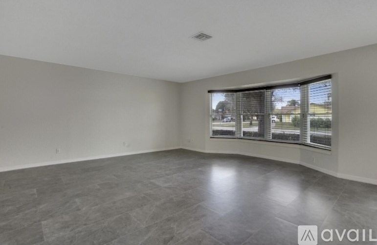 A spacious room with a large window and a view of the outside.