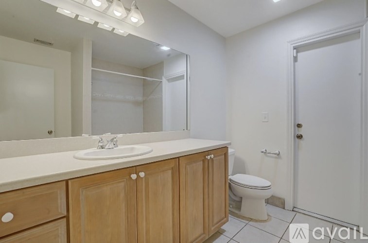 A bathroom with a sink, toilet, and mirror.