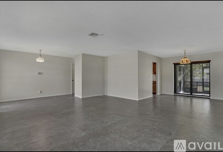 A spacious room with a grey floor and white walls.