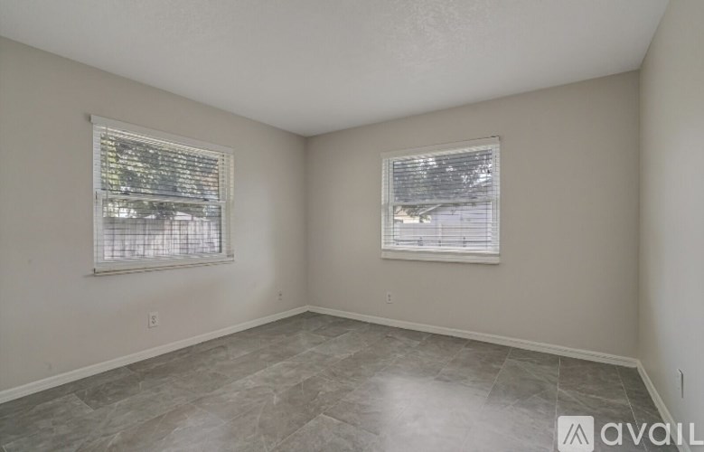 A room with two windows and tiled flooring is available for rent.