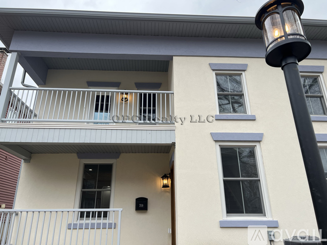 A building with a balcony and a lamp post in front.