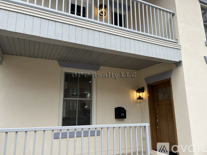 A balcony with a railing and a window with a sign that says "OFG Realty LLC".