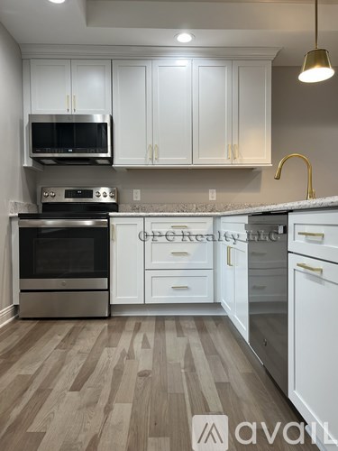 A kitchen with white cabinets and a wooden floor.
