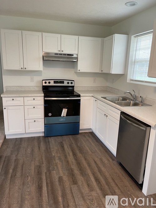 A kitchen with white cabinets and a black stove top oven.