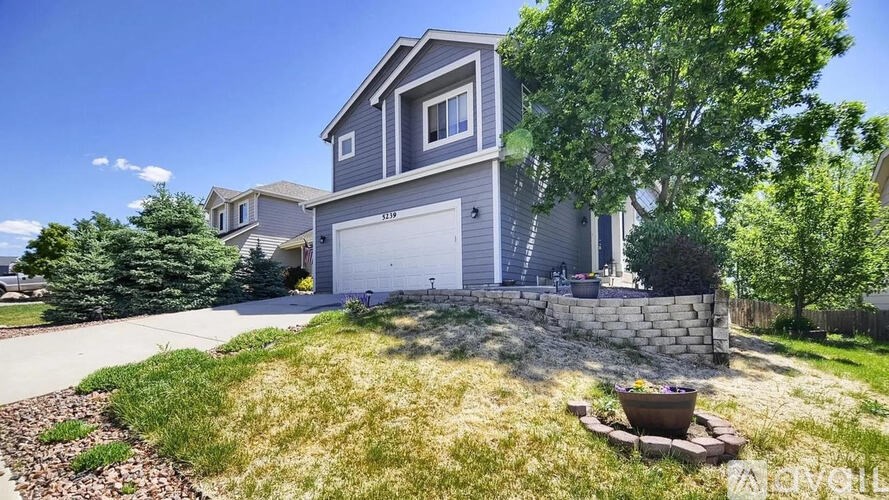 A house with a grey exterior and a white garage door.