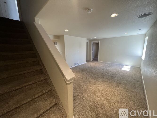 A staircase with a carpeted floor and a wall with a door.