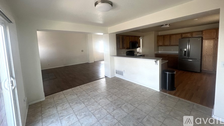 A kitchen area with a refrigerator, sink, and cabinets.