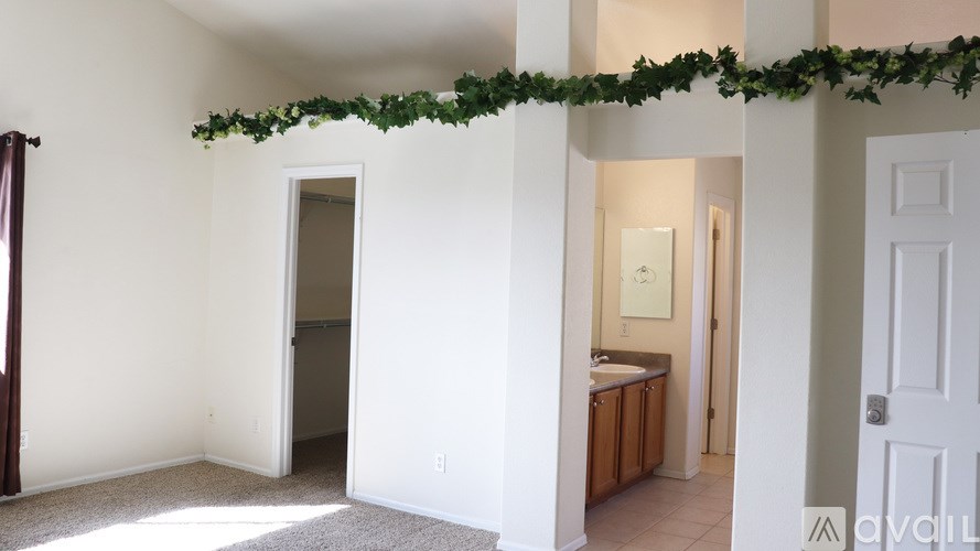 A room with a doorway leading to another room, decorated with a garland.