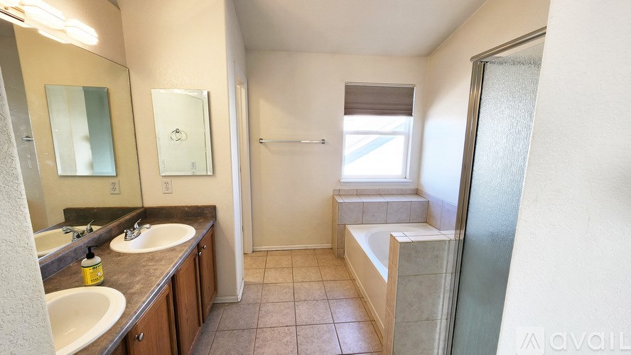 A bathroom with a sink, mirror, and bathtub.