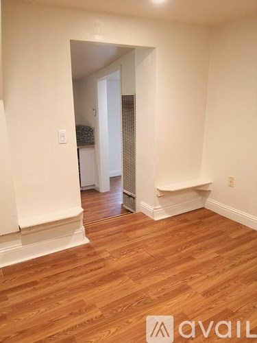A hallway with a bench and a door.