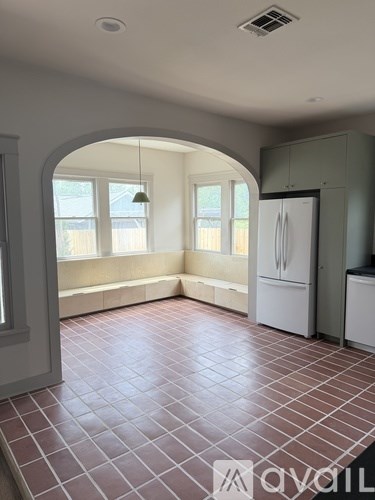 A large open kitchen and living room with a chandelier hanging from the ceiling.