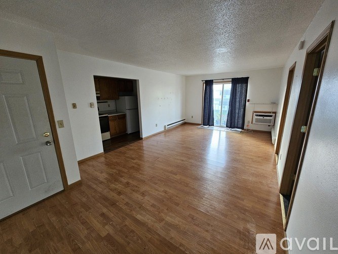 A room with wooden flooring and a white door.