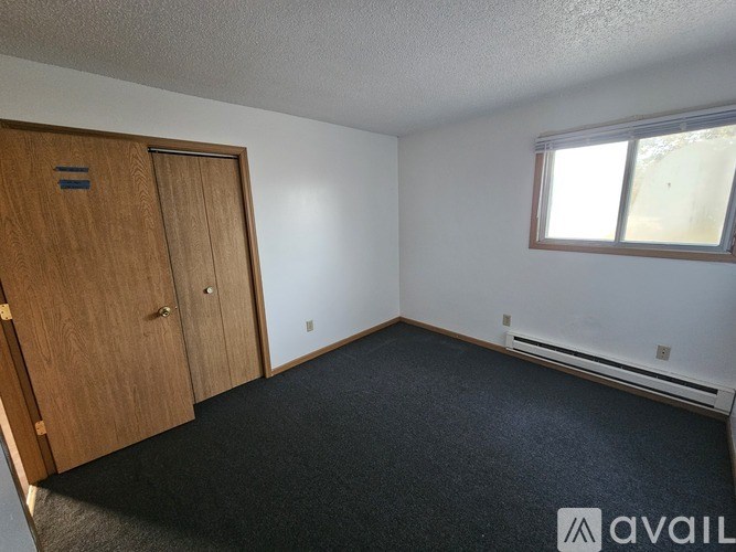 A room with a wooden door and a window with a white frame.