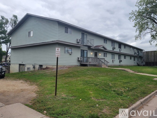 A grey building with a sign that says "No Parking" in front of it.