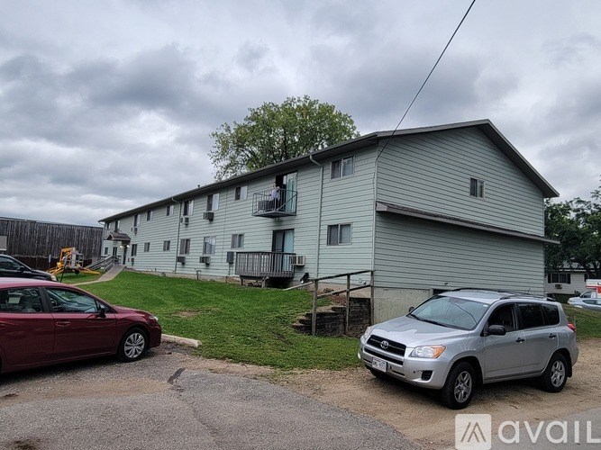 A silver SUV is parked in front of a grey house.