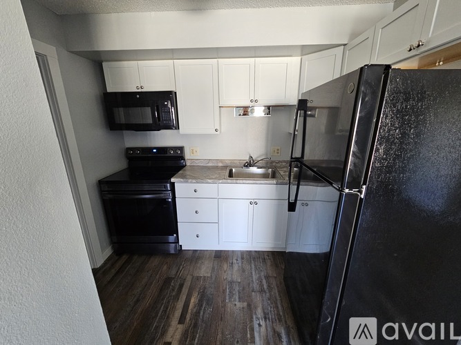 A room with wooden flooring and white walls is available for rent.