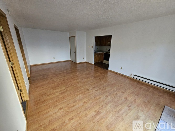 A room with wooden flooring and white walls is available for rent.