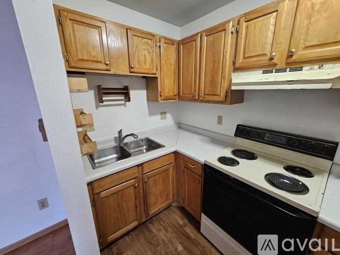 A kitchen with wooden cabinets and a black stove top oven.