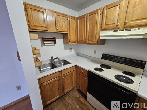 A kitchen with wooden cabinets and a black stove top oven.
