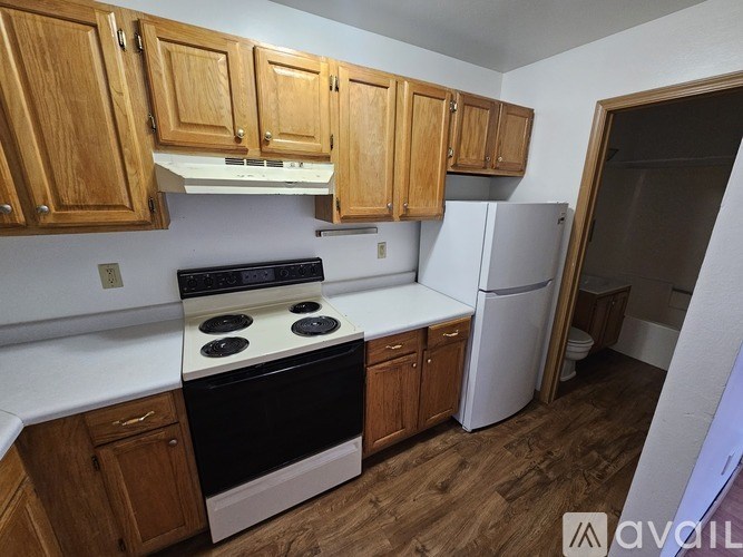 A kitchen with wooden cabinets and a black stove top oven.