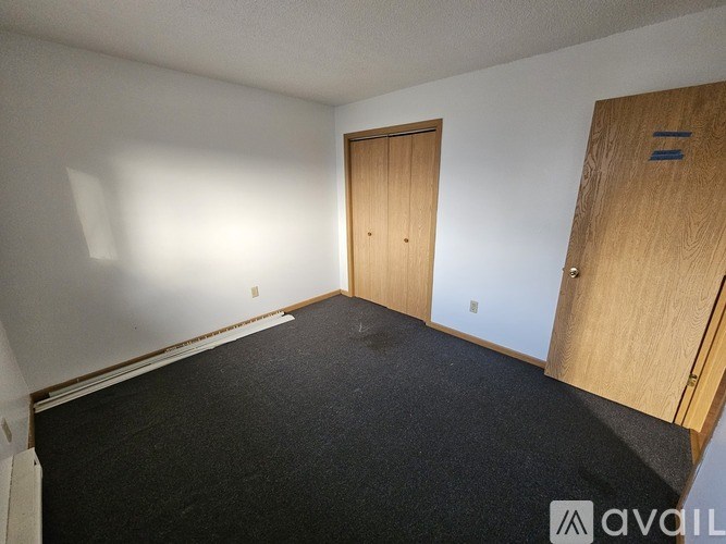 A room with two wooden doors and a carpeted floor.