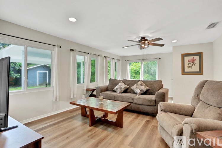 A living room with a couch, a coffee table, and a television.