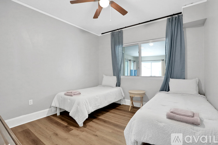 A bedroom with two beds and a ceiling fan.
