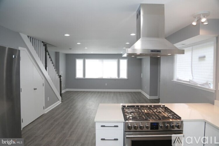 A modern kitchen with a stove top oven and a staircase.