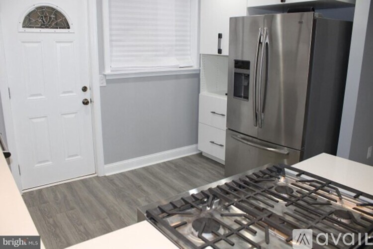 A kitchen with a stove top oven and a refrigerator.
