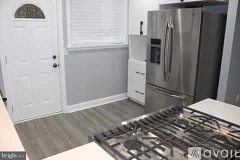 A kitchen with a stove top oven and a refrigerator.