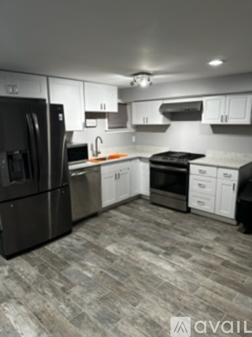 A kitchen with black appliances and white cabinets.