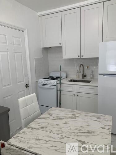 A kitchen with white cabinets and appliances.