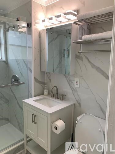 A bathroom with a marble wall and a white sink.