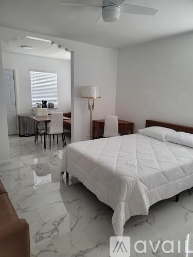 A bedroom with a bed, desk, and chair.