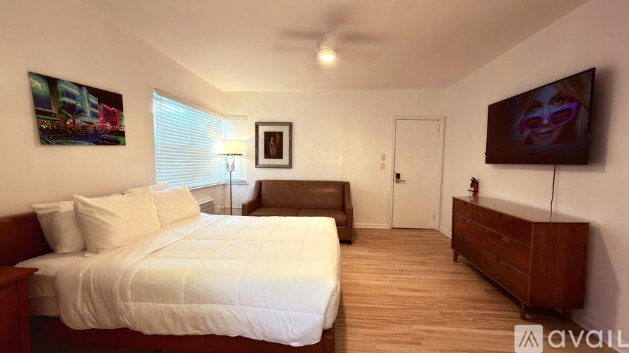 A bedroom with a large bed and a flat screen TV mounted on the wall.