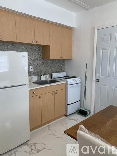 A kitchen with a white fridge, a white dishwasher, and wooden cabinets.