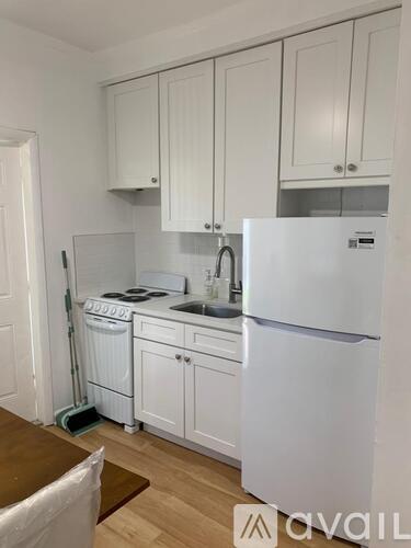 A kitchen with white appliances and cabinets.