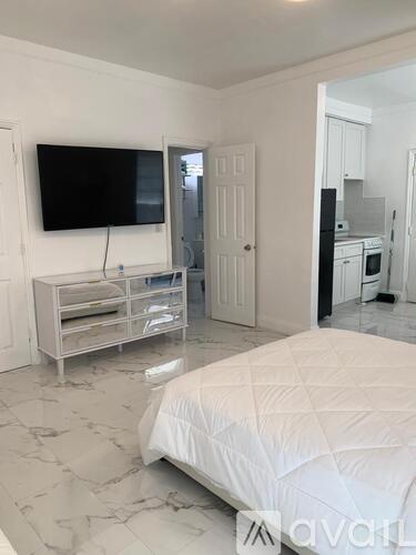 A bedroom with a bed, a television, and a cabinet.