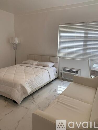 A bedroom with a large bed and a couch.