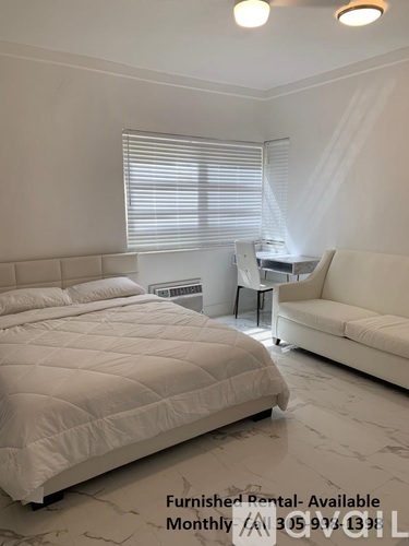 A bedroom with a large bed and a couch is available for rent.