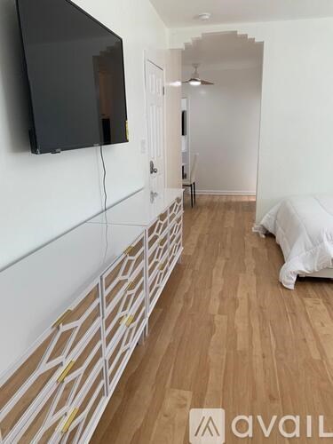 A room with a wooden floor and a wall with a patterned border.