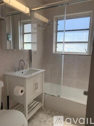 A bathroom with a toilet, sink, and shower.