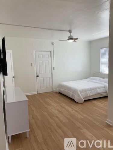 A bedroom with a bed, dresser, and ceiling fan.