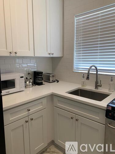 A kitchen with white cabinets and a sink.