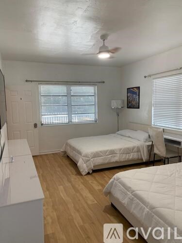 A bedroom with two beds and a ceiling fan.