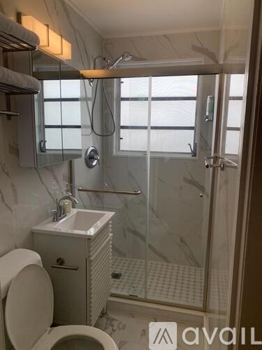 A bathroom with a toilet, sink, and shower.