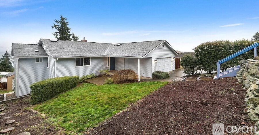 A house with a grey roof and a white garage door.