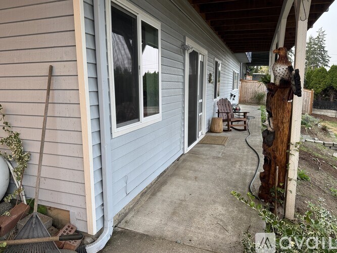 A blue house with a porch and a bird statue.