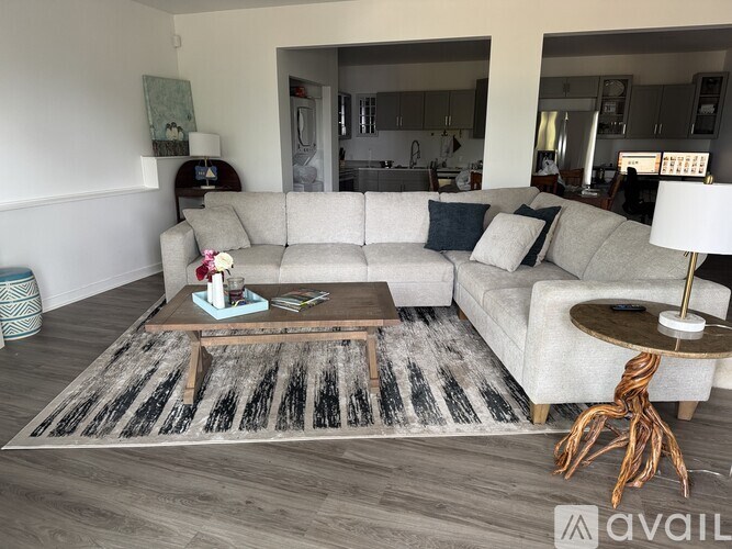 A living room with a grey couch and a wooden coffee table.